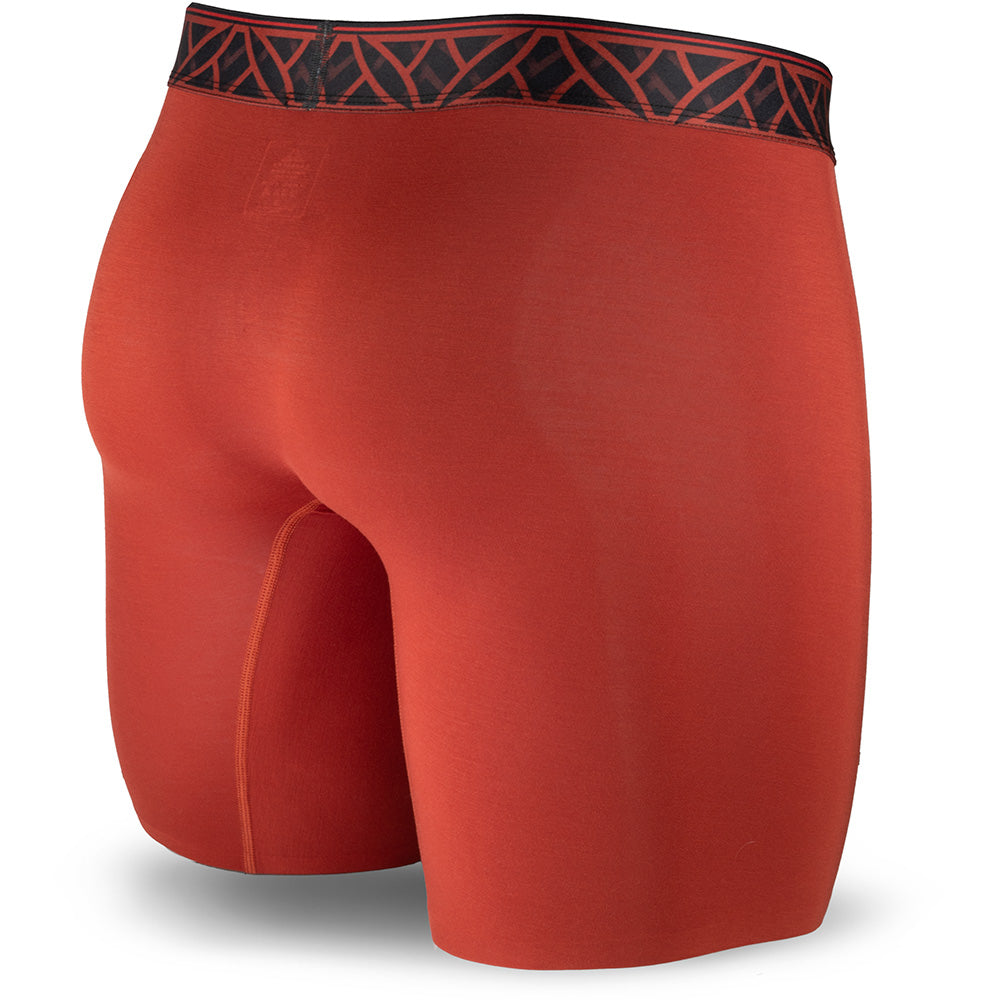 Red athletic shorts with black geometric waistband on a white background