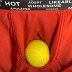 Red underwear with a yellow tennis ball inside, black waistband with white text.