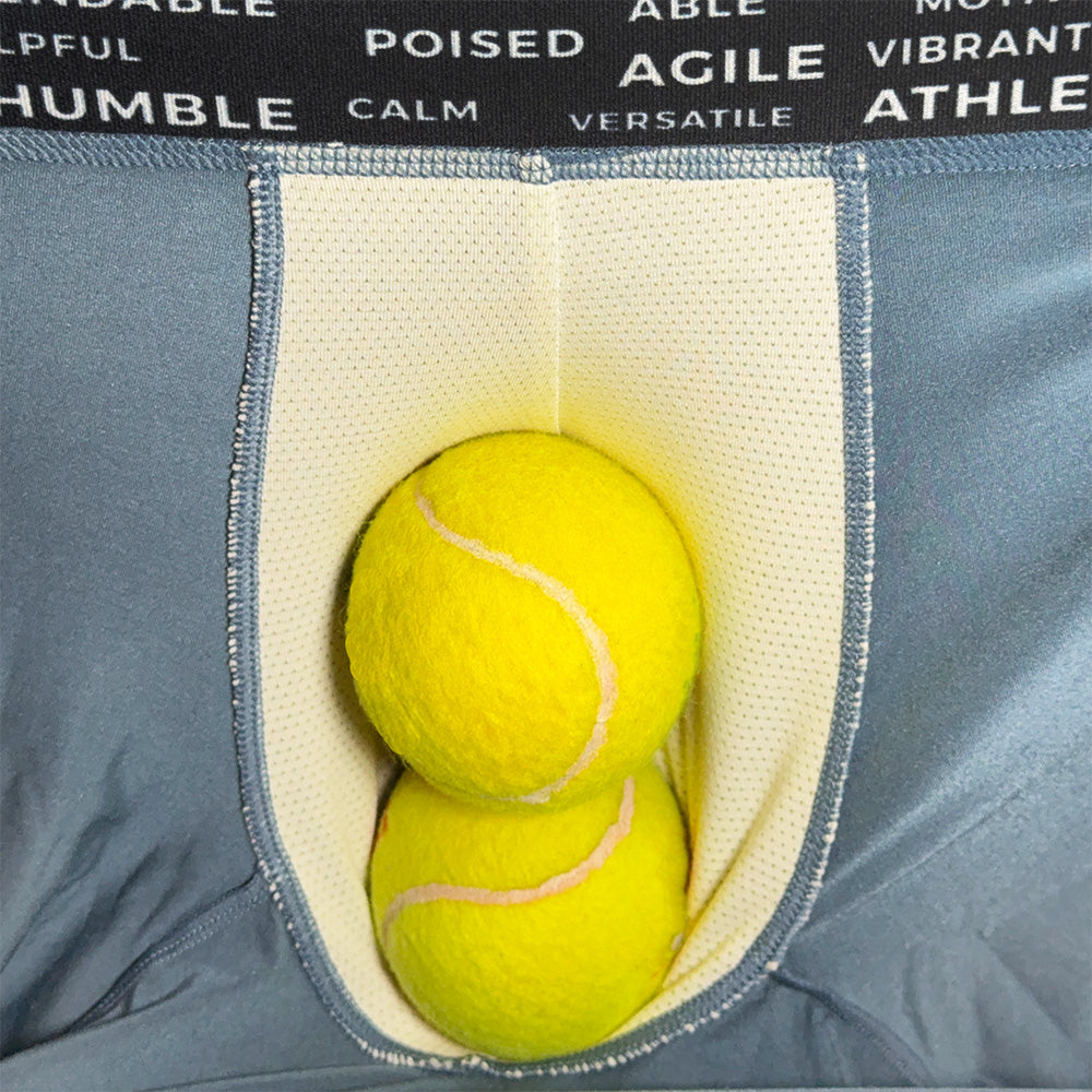 Two yellow tennis balls in a pocket with motivational words above on a gray background
